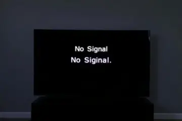 A dark TV displays "No Signal," reflecting a frustrated person in a dim living room.