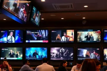 alt_text: A lively modern restaurant at night, with wall-mounted TVs showing music videos as patrons dine in the warm, ambient lighting.